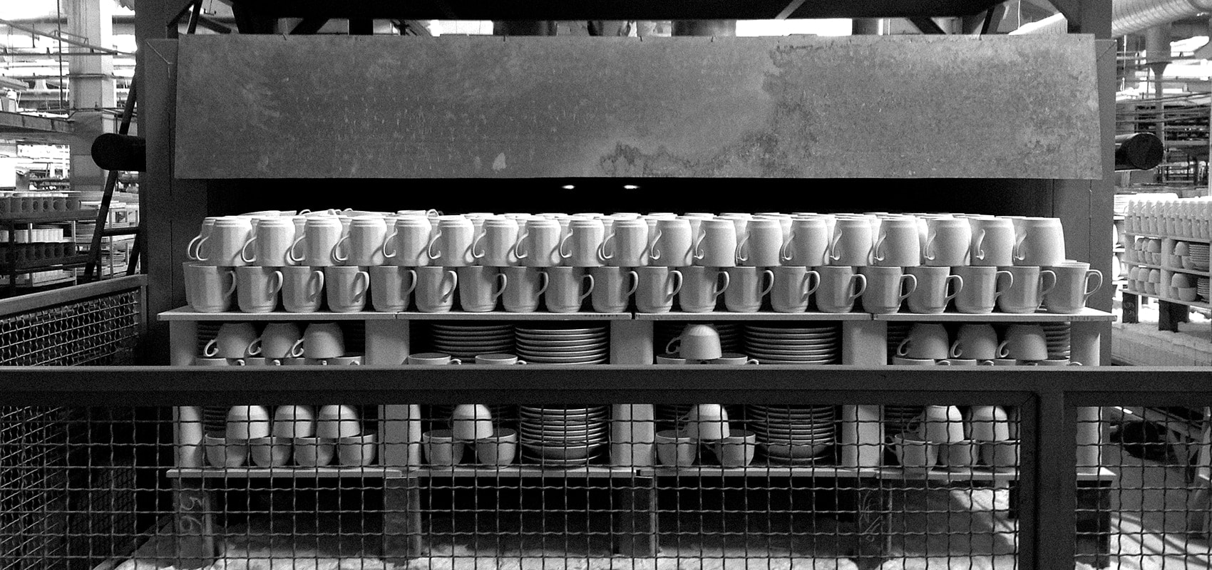 Línea de producción industrial con tazas y platos apilados