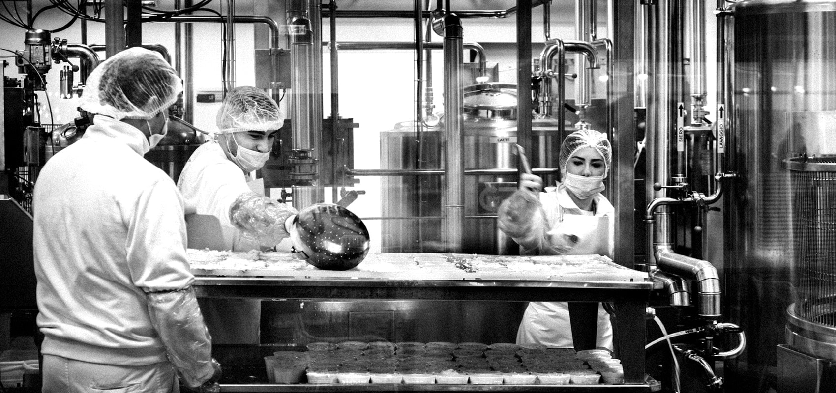 Trabajadores con indumentaria sanitaria manipulando alimentos
