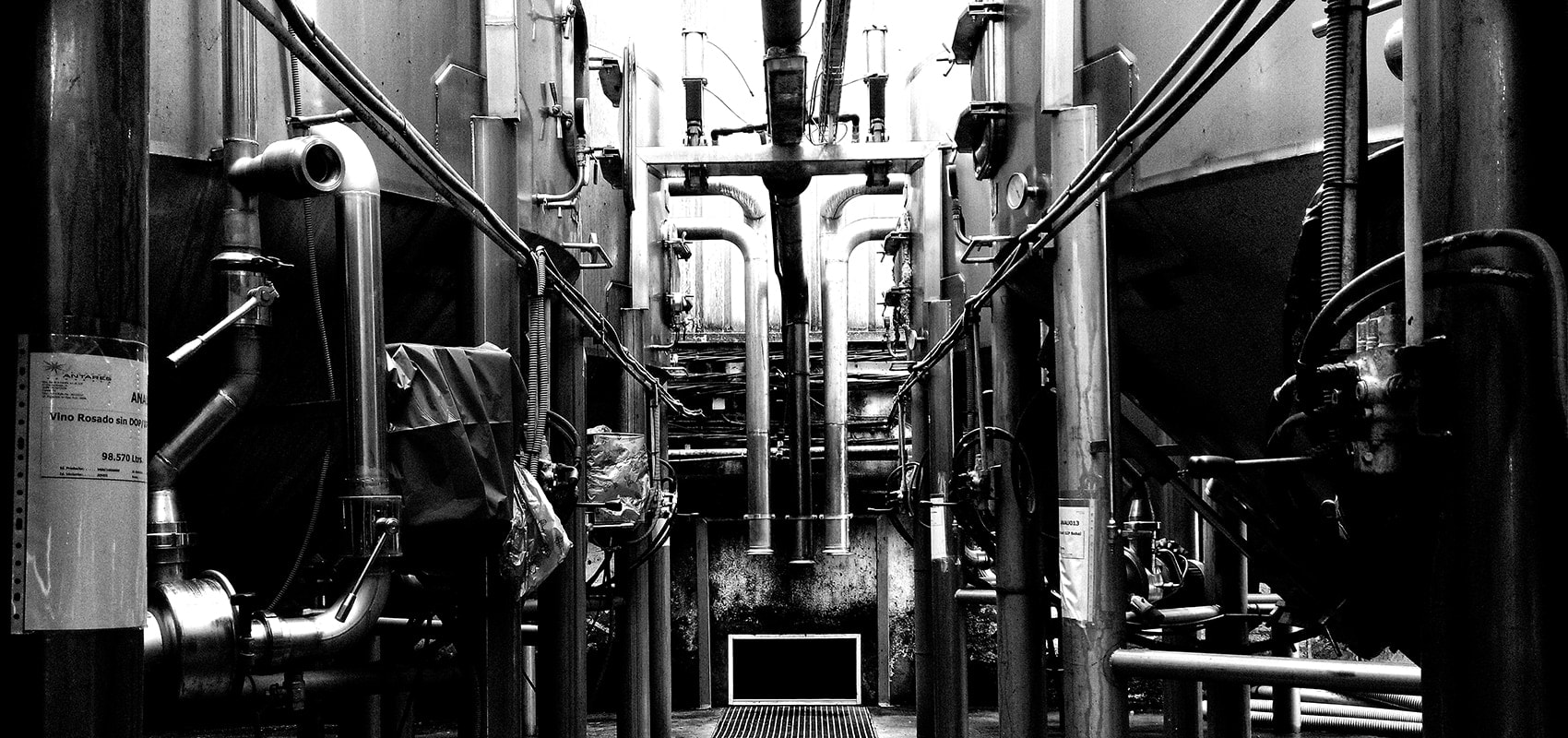 Interior de una instalación industrial con depósitos, tuberías y válvulas